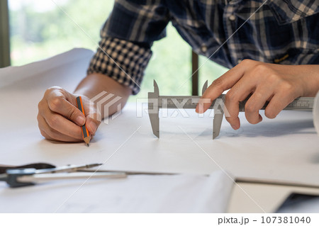 architect working with blueprints, engineer inspection in workplace for architectural plan, sketching a construction project architect working with blueprints, engineer inspection in workplace for architectural plan, sketching a construction project 107381040