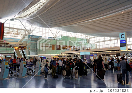 出発手続きで混雑する羽田空港第3ターミナルの出発ロビー（中央向き） 107384828
