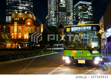 ライトアップされた東京駅をバックに発車する都営バスのアップ（三菱ふそう・エアロスター） 107384833