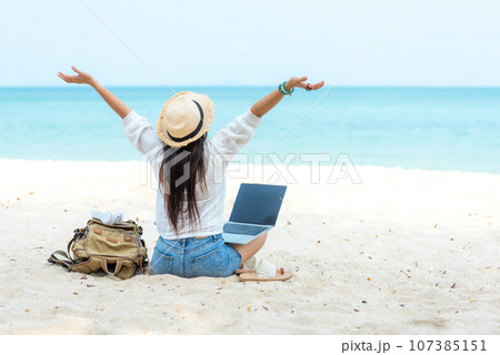 Lifestyle freelance woman raise arms relax after using laptop working on the beach 107385151