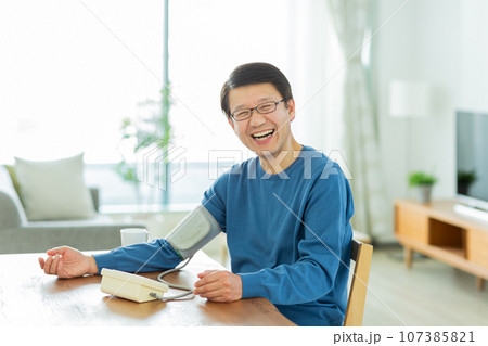 血圧を測るシニア男性 107385821
