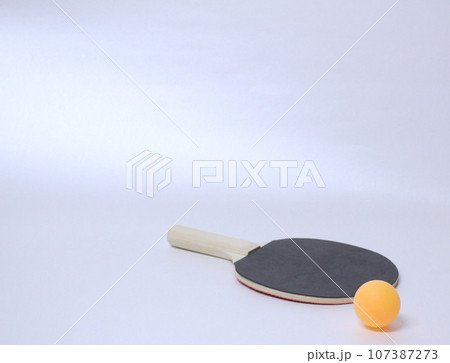 画面右下にある卓球ラケットの黒い面の上に乗るピンポン玉 白バック 画面右下にある卓球ラケットの黒い面の上に乗るピンポン玉 白バック 107387273