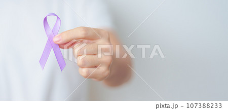 woman holding Purple Ribbon for Stomach, Violence, Pancreatic, Esophageal, Testicular cancer, Alzheimer, epilepsy, lupus, Sarcoidosis and Fibromyalgia. Awareness month and World cancer day concept woman holding Purple Ribbon for Stomach, Violence, Pancreatic, Esophageal, Testicular cancer, Alzheimer, epilepsy, lupus, Sarcoidosis and Fibromyalgia. Awareness month and World cancer day concept 107388233