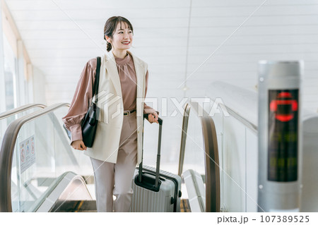 空港・駅のエスカレーターを昇る出張のビジネスウーマン（出勤・通勤） 107389525