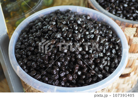 slices black olives with spoon in a bowl , 107391405