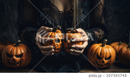 Woman's hands and Halloween pumpkins 107393748