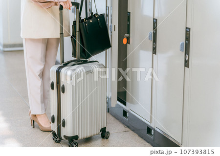 駅・商業施設のコインロッカーに荷物を預ける女性(海外旅行・キャリーバッグ・キャビネット) 駅・商業施設のコインロッカーに荷物を預ける女性(海外旅行・キャリーバッグ・キャビネット) 107393815