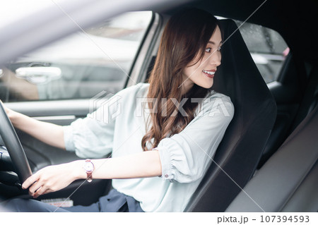 後方確認をするビジネスカジュアル姿の若い女性 後方確認をするビジネスカジュアル姿の若い女性 107394593