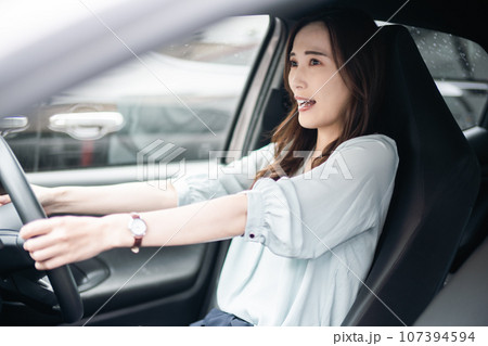 運転をしながら危険に驚く若い女性 運転をしながら危険に驚く若い女性 107394594