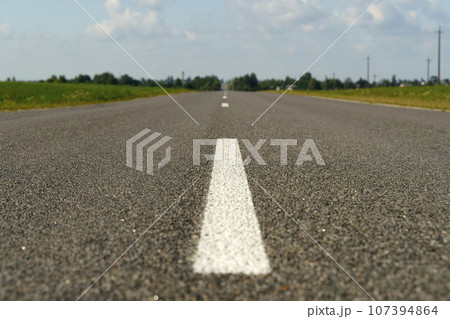 Automobile road with asphalt and framed in summer. Empty straight road. Automobile road with asphalt and framed in summer. Empty straight road. 107394864
