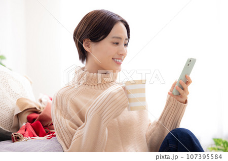 リビングでスマホを見る女性 リビングでスマホを見る女性 107395584