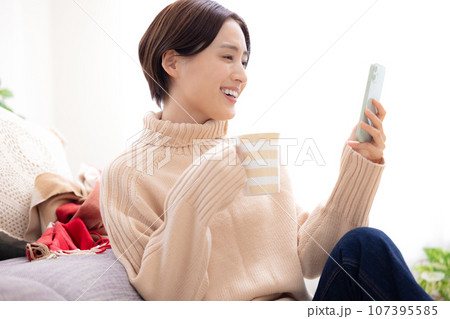 リビングでスマホを見る女性 リビングでスマホを見る女性 107395585