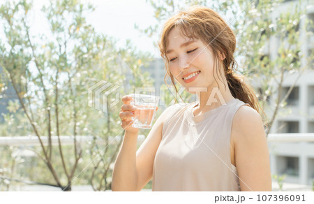 水・白湯・ミネラルウォーター・ぬるま湯を飲むアジア人女性（運動・ヨガ・ダイエット） 107396091