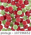Texture of randomly scattered gelatin candies of red-green colors, in the form of buns sprinkled with sugar. 107396652
