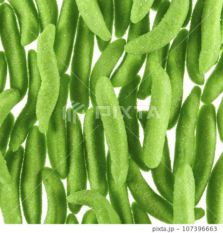 Texture of randomly scattered gelatin candies made in the form of green pea pods sprinkled with sugar. 107396663