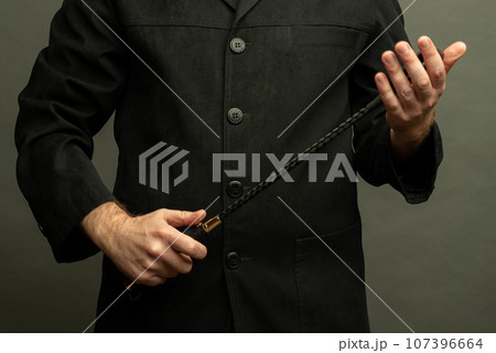 male dominant holds a leather whip Flogger for hard BDSM sex with spanking male dominant holds a leather whip Flogger for hard BDSM sex with spanking 107396664