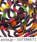 Texture of randomly scattered gelatin candies made in the form of colorful snakes. Gelatin cobras. 107396671