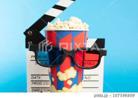 Movie clapper, pop corn, 3D glasses and film reel on blue background. Collage design Movie clapper, pop corn, 3D glasses and film reel on blue background. Collage design 107396809