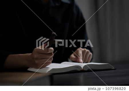 Closeup of simple wooden Christian cross on Bible. Concept of hope, faith, christianity, religion. Closeup of simple wooden Christian cross on Bible. Concept of hope, faith, christianity, religion. 107396820