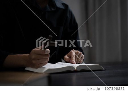 Closeup of simple wooden Christian cross on Bible. Concept of hope, faith, christianity, religion. Closeup of simple wooden Christian cross on Bible. Concept of hope, faith, christianity, religion. 107396821