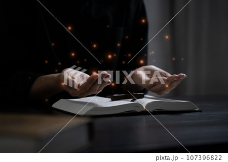Closeup of simple wooden Christian cross on Bible. Concept of hope, faith, christianity, religion. 107396822