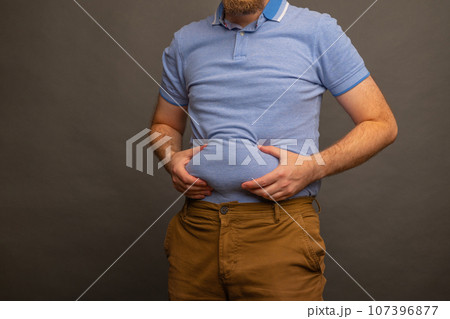 Overweight man in t-shirt on grey background, closeup. Space for text 107396877