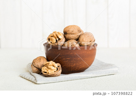 Fresh healthy walnuts in bowl on colored table background. Top view Healthy eating bertholletia concept. Super foods Fresh healthy walnuts in bowl on colored table background. Top view Healthy eating bertholletia concept. Super foods 107398822