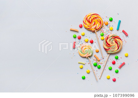 Tasty appetizing Party Accessories Happy Birthday Sweet. Different types of candies on colored background, copy space. Colorful birthday party background Tasty appetizing Party Accessories Happy Birthday Sweet. Different types of candies on colored background, copy space. Colorful birthday party background 107399096