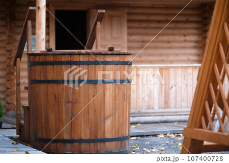 A barrel for dipping after an outdoor sauna. Barrel of water near the bathhouse A barrel for dipping after an outdoor sauna. Barrel of water near the bathhouse 107400728