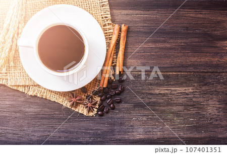Cup of coffee and ears on dark wooden table background. 107401351