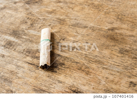 Cigarette butt discarded outdoors on the wooden table Cigarette butt discarded outdoors on the wooden table 107401416