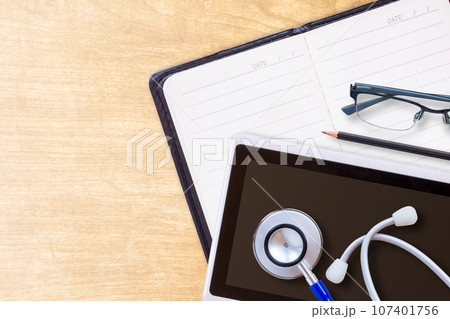 Diary planner book in black leather and stethoscope Diary planner book in black leather and stethoscope 107401756