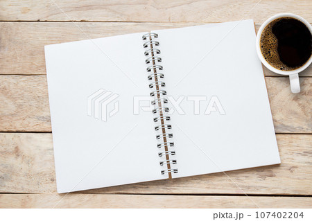 Blank paper notebook on brown wooden table background. Top view with copy space (selective focus). 107402204