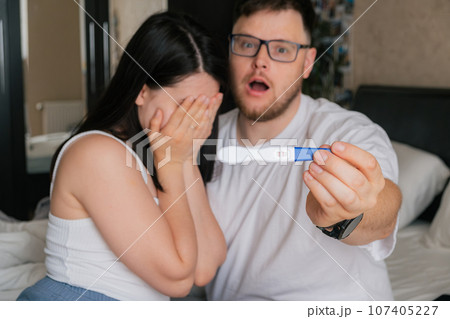 worried couple looking at positive pregnancy test worried couple looking at positive pregnancy test 107405227