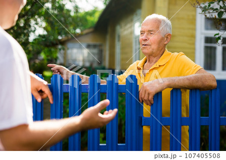 Good neighbors talk on border of their farms Good neighbors talk on border of their farms 107405508