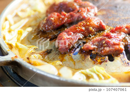 焼肉用鉄板で牛肉を焼く 107407061
