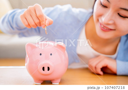 貯金をする若い女性 貯金をする若い女性 107407218
