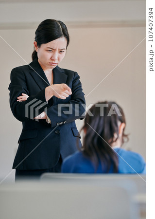腕組みをして女の子を叱る女性の教師 腕組みをして女の子を叱る女性の教師 107407394