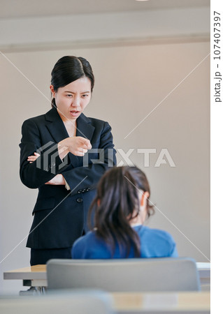 腕組みをして女の子を叱る女性の教師 腕組みをして女の子を叱る女性の教師 107407397