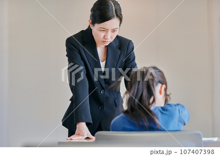 女の子を叱る女性の教師 107407398