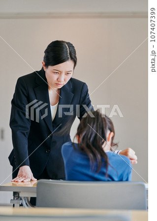 女の子を叱る女性の教師 107407399