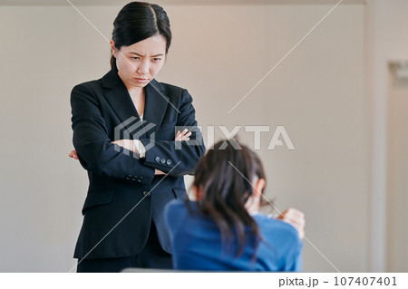 腕組みをして女の子を叱る女性の教師 腕組みをして女の子を叱る女性の教師 107407401