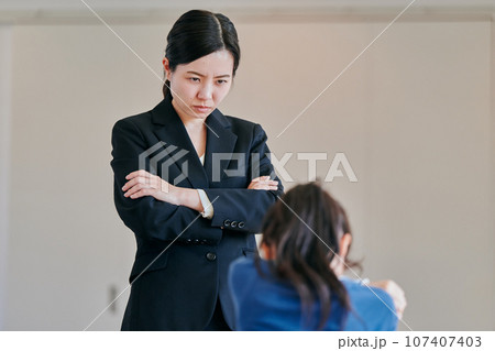 腕組みをして女の子を叱る女性の教師 腕組みをして女の子を叱る女性の教師 107407403