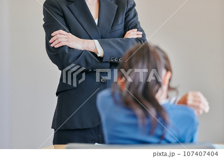 腕組みをして女の子を叱る女性の教師 腕組みをして女の子を叱る女性の教師 107407404