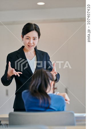 イライラしながら女の子を叱る女性の教師 イライラしながら女の子を叱る女性の教師 107407410