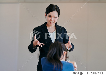 イライラしながら女の子を叱る女性の教師 イライラしながら女の子を叱る女性の教師 107407411