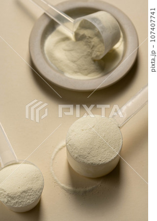 Protein powder in a measuring scoops 107407741