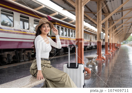 Young woman asian sitting and waiting for the train waiting for the train to go traveling. Travel concept 107409711