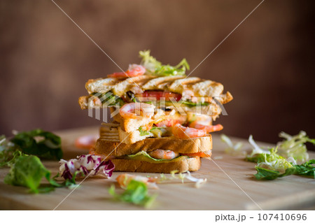 sandwich with lettuce and shrimp. 107410696