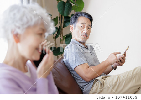 スマートフォンで会話をするシニア女性と男性 107411059
